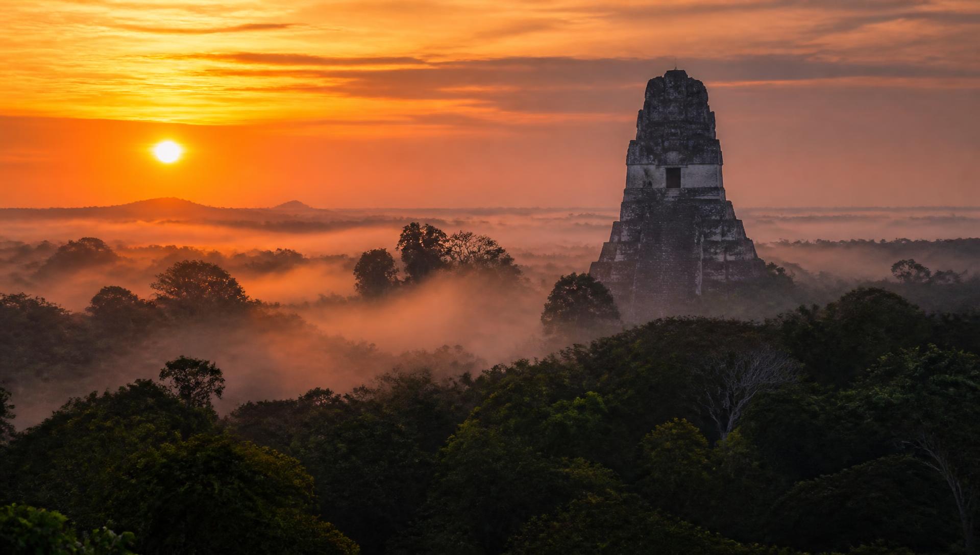 Temple I at Tikal rising above mist-covered jungle canopy at sunrise in Guatemala