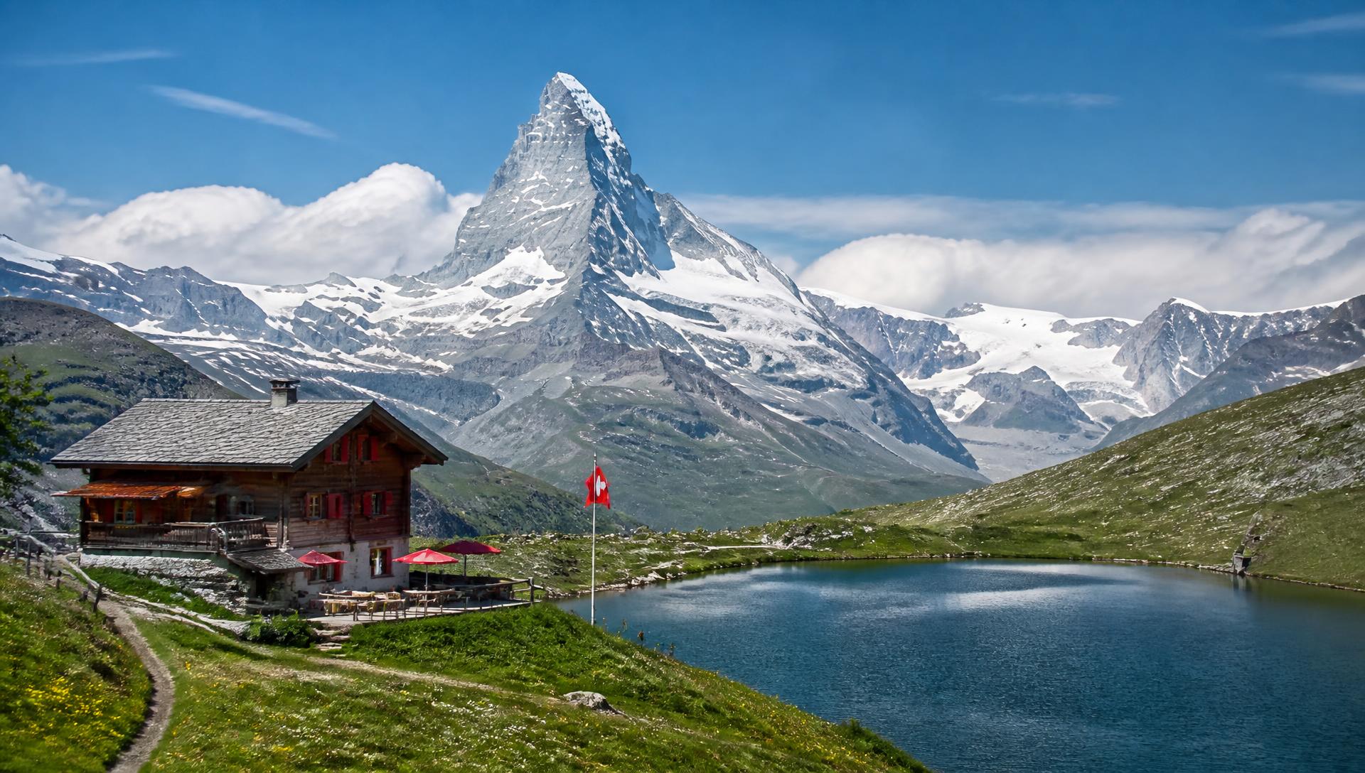 The Matterhorn rising above an alpine lake and a wooden chalet in the Swiss Alps